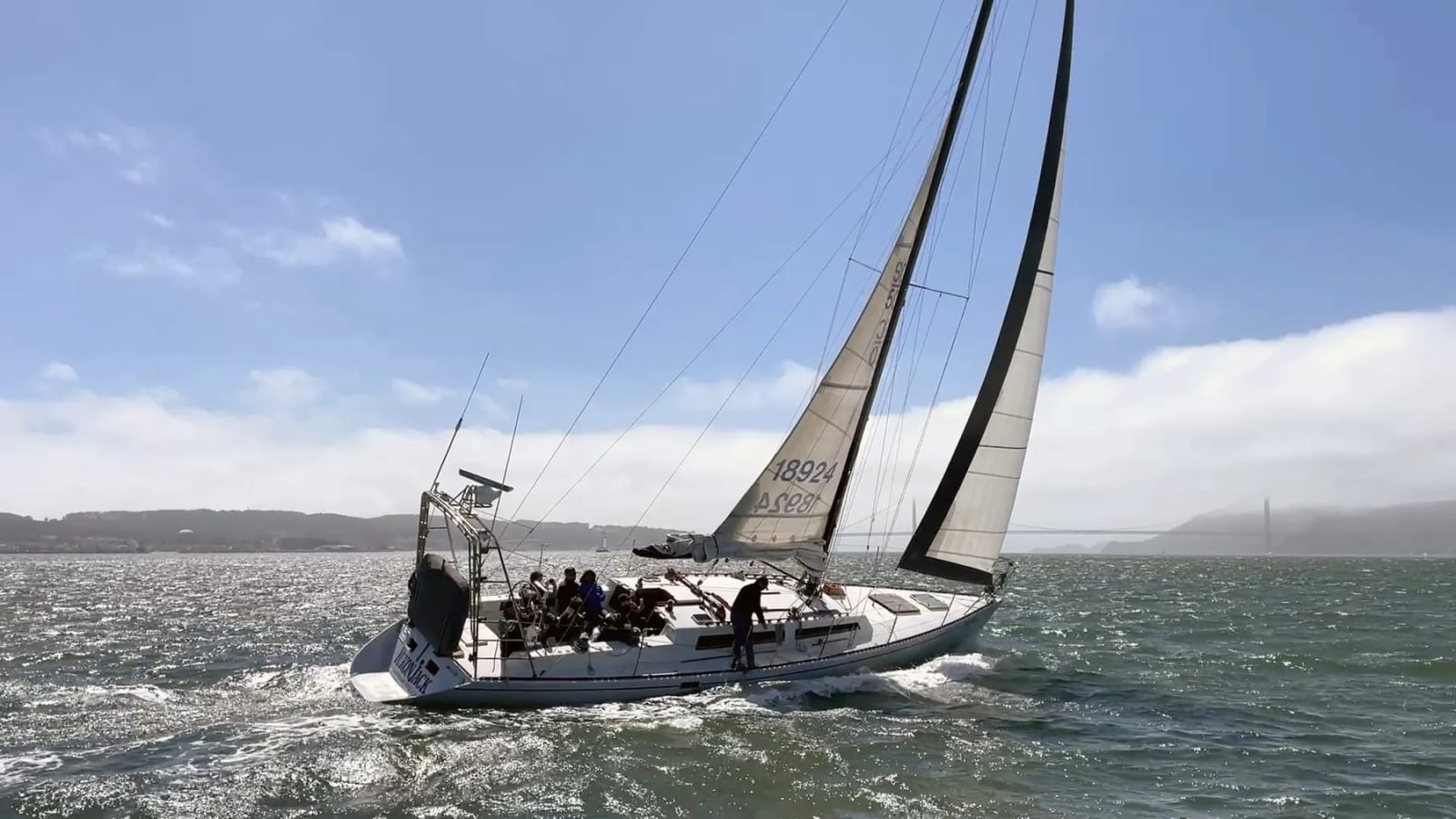 Yukon Jack under full sail on San Francisco Bay with the Golden Gate Bridge in fog behind